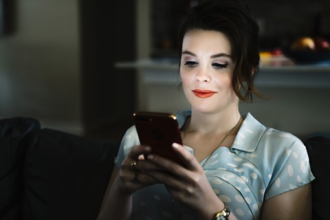 Woman texting on cell phone in the dark