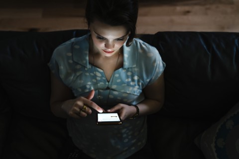 Woman texting on cell phone in the dark