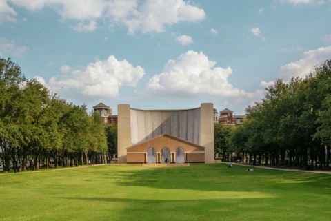 Scenic view of tree-lined lawn near building