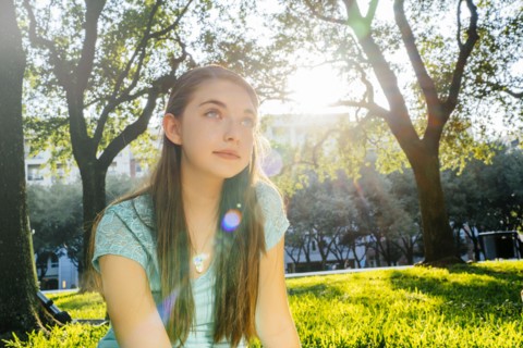Portrait of pensive Caucasian girl in park