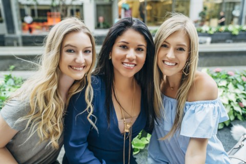 Wind blowing hair of smiling women