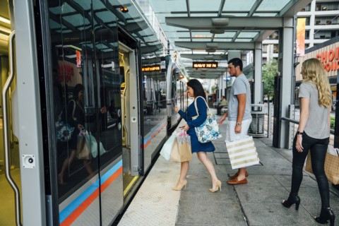 Friends boarding train carrying shopping bags