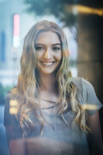 Portrait of smiling Caucasian woman behind window