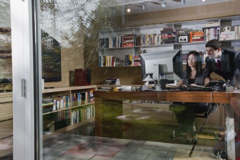 Mixed race businesswoman sitting at desk with co-worker