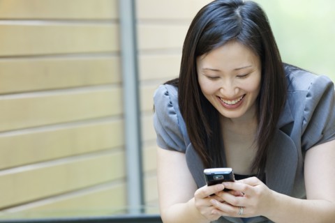 Asian businesswoman looking at cell phone