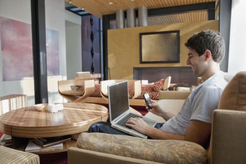Middle Eastern man using laptop and cell phone