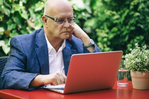 Hispanic businessman using laptop outdoors