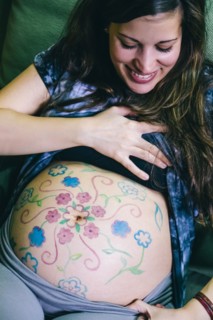 Pregnant Caucasian woman with drawings on belly