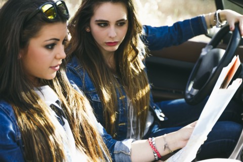Women reading map on road trip