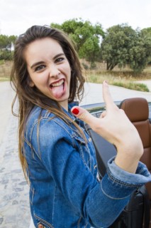 Caucasian woman making a face near car