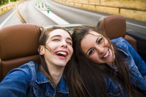 Women laughing in convertible