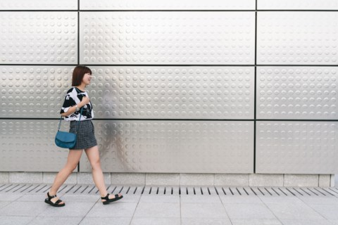 Chinese woman walking on sidewalk