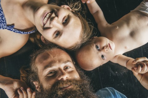 Caucasian parents laying on floor with daughter
