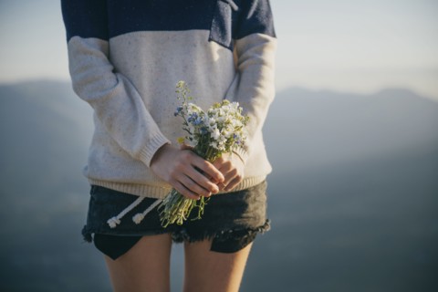 Caucasian woman holding bouquet of wildflowers