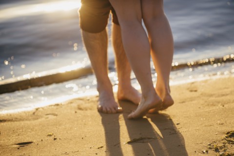 Legs of couple hugging at beach