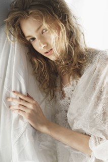 Portrait of serious Caucasian woman leaning on sheet