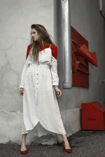 Caucasian woman wearing dress leaning on corner