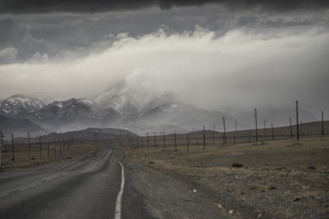 Clouds over road to mountain landscape