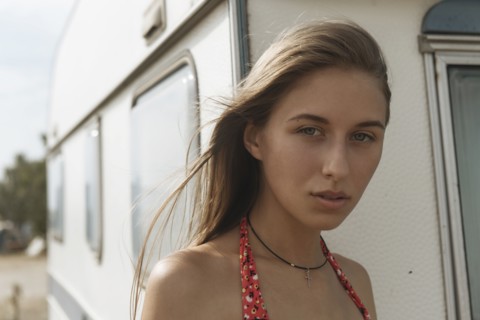 Serious Caucasian woman standing near trailer