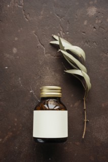 Alternative medicine jar with blank label near leaf