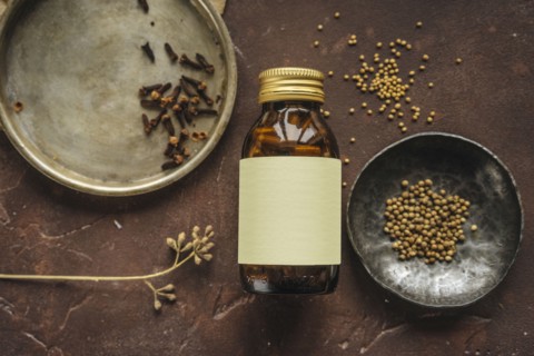 Alternative medicine jar with blank label near seeds