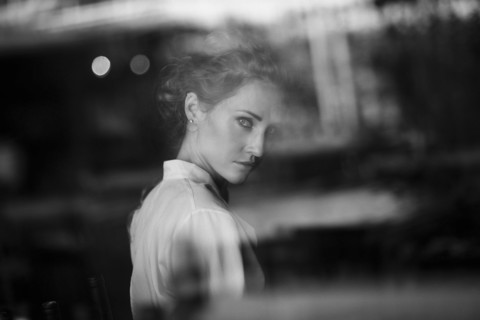 Portrait of serious Caucasian woman behind window