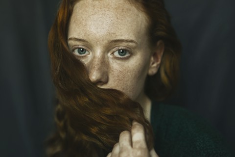 Caucasian woman covering mouth with hair
