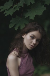 Caucasian woman standing under leaves