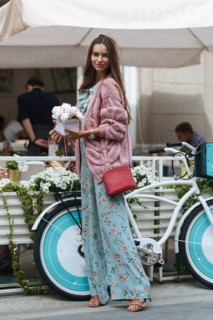 Caucasian woman carrying gift box near bicycle