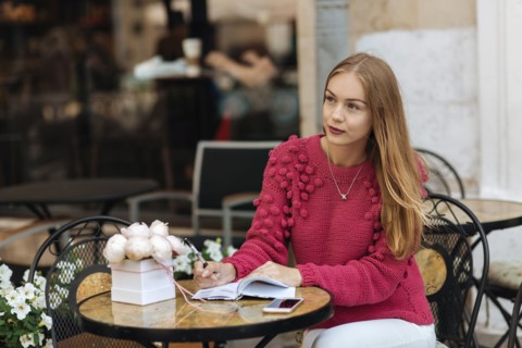 Caucasian woman sitting at table writing in journal