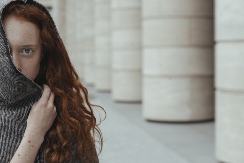Caucasian woman hiding face behind hood