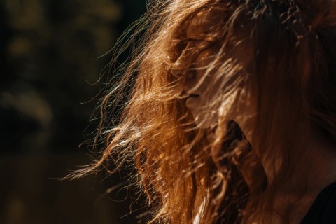 Wind blowing red hair of Caucasian woman