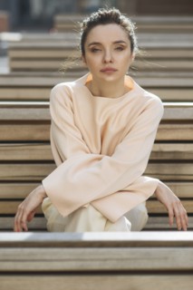 Portrait of serious Caucasian woman sitting on wooden bench