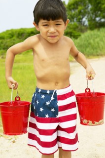 Boy carrying buckets at beach