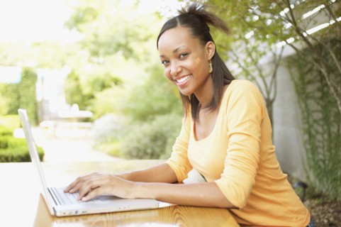 Portrait of teenage girl typing on laptop