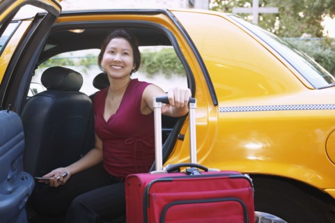 Young woman with suitcase inside a cab
