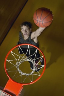 Basketball player about to slam dunk the ball