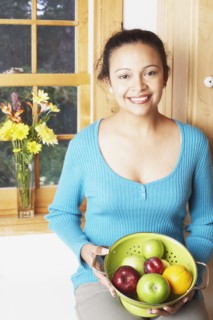 Young woman holding a bowl of fruit