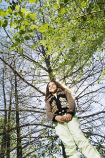 Low angle view of young girl under tree