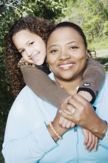 African mother and daughter hugging outdoors