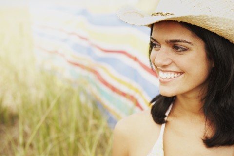 Woman wearing straw hat in field