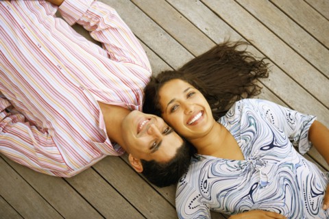 Young couple laying on deck