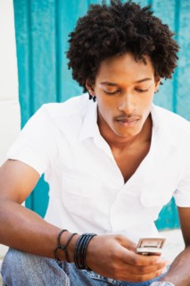 African man looking down at cell phone