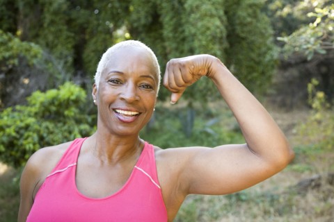 Mixed race woman flexing muscles outdoors