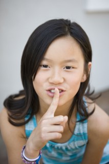 Chinese girl making shhh gesture