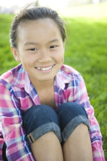Smiling Chinese girl sitting in grass