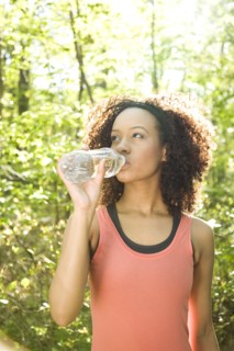 Hispanic woman drinking water after exercise