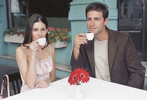 Hispanic couple drinking coffee at outdoor cafe