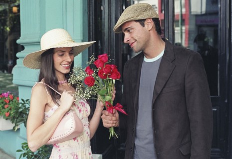 Hispanic man giving flowers to girlfriend