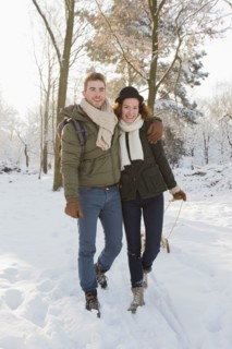Caucasian couple pulling sled in snow